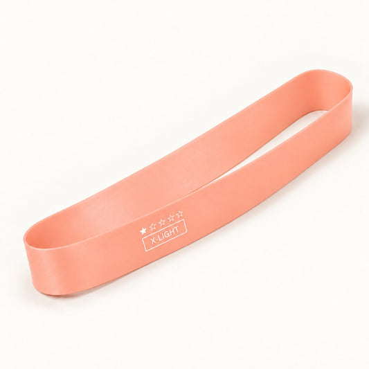 One tender pink natural latex resistance loop band, shown individually on an ivory background.